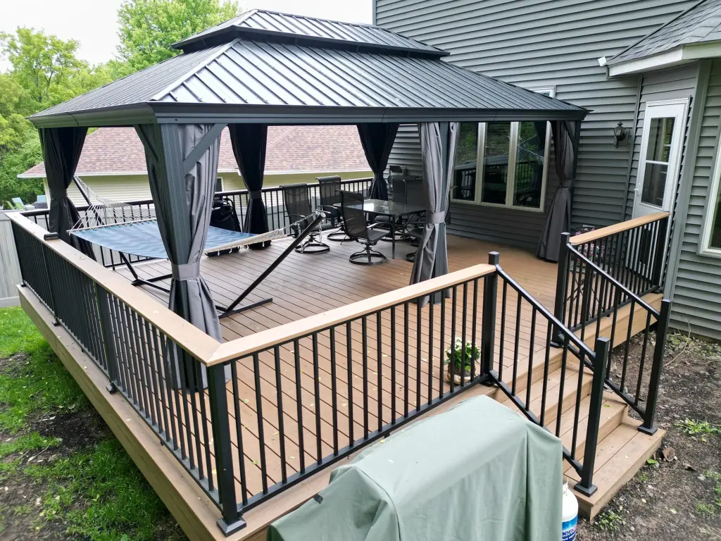 raised-deck-installation-with-big-wooden-pergola-and-curtains-with-outdoor-living-dining-set-area-attached-on-modern-house-in-twin-cities-mn